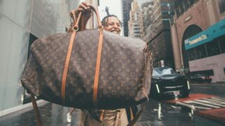 Pessoa segurando e exibindo uma bolsa da Louis Vuitton