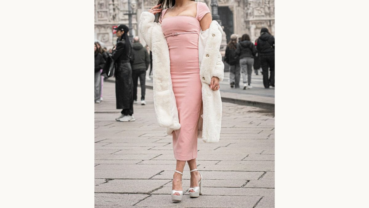 Mulher posa com vestido midi e salto alto