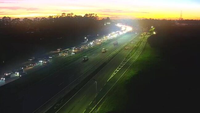 A imagem mostra uma rodovia com bastante veículos
