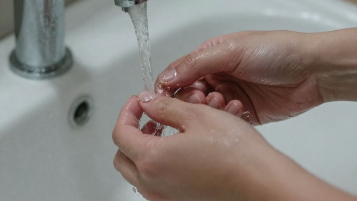 Mãos molhadas enquanto lavam louça