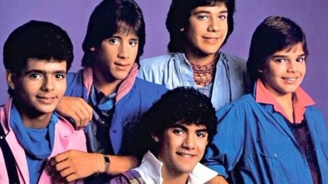 Boy band Menudo dos anos 80, posando contra um fundo roxo, incluindo Ricky Martin.