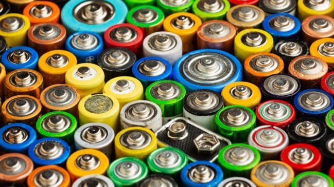 Pilhas e baterias usadas de diferentes tamanhos e cores agrupadas para reciclagem e descarte adequado.