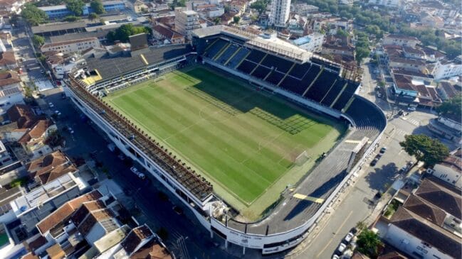Fotografia aérea de plano aberto mostrando o estádio Urbano Caldeira integrado ao tradicional bairro da Vila Belmiro em Santos