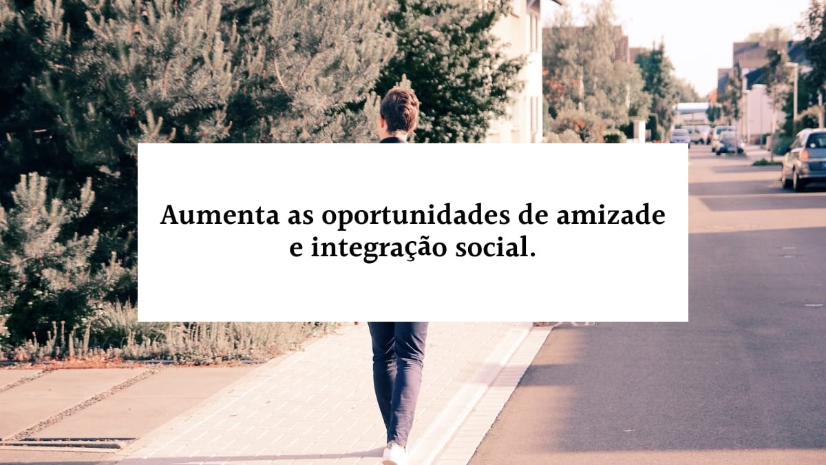 Banner com a frase aumenta as oportunidades de amizade e integração social em letras pretas dentro de uma faixa branca horizontal, sobreposta à imagem de uma pessoa caminhando de costas por uma calçada residencial.