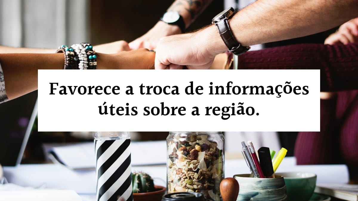 Banner com a frase favorece a troca de informações úteis sobre a região escrita em letras pretas dentro de uma faixa branca, sobreposta à imagem de pessoas unindo as mãos em equipe sobre uma mesa.