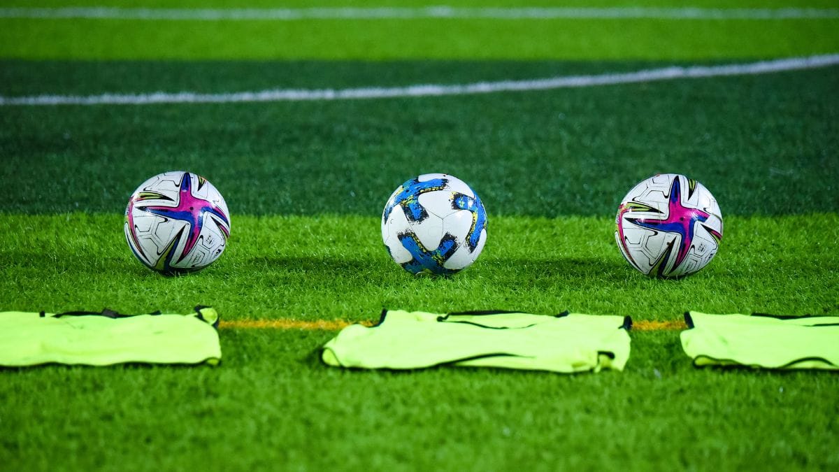 Bola de futebol na cor branca e detalhes em azul, rosa e verde