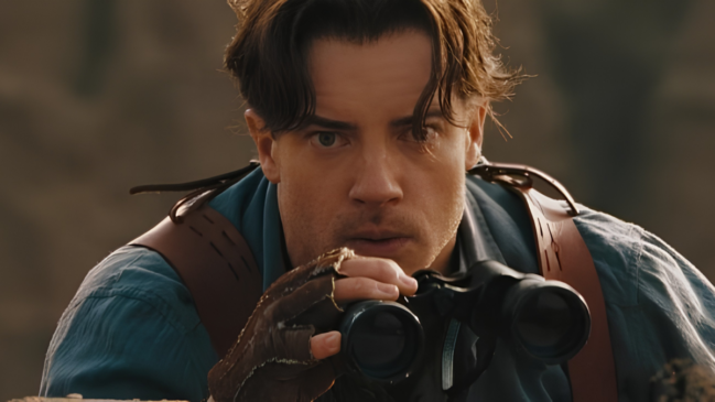 Brendan Fraser olhando em um binóculo em cena de 'A Múmia: Tumba do Imperador Dragão'