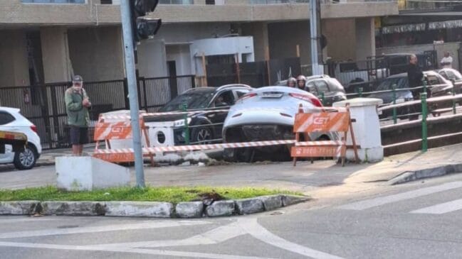 Imagem do veículo prata pendurado na mureta do Canal 5, em Santos