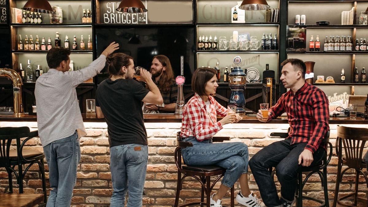 Clientes consomem cervejas em mesa de bar
