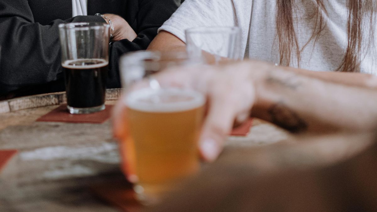 Clientes consomem cervejas em mesa de bar