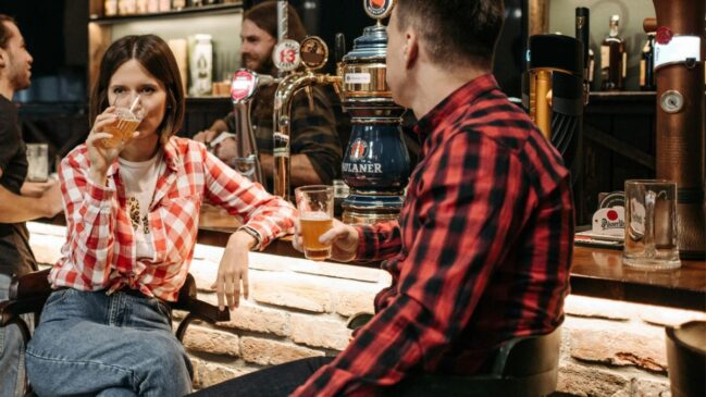 Clientes consomem cervejas em mesa de bar