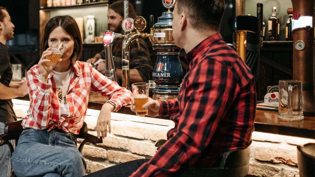 Clientes consomem cervejas em mesa de bar