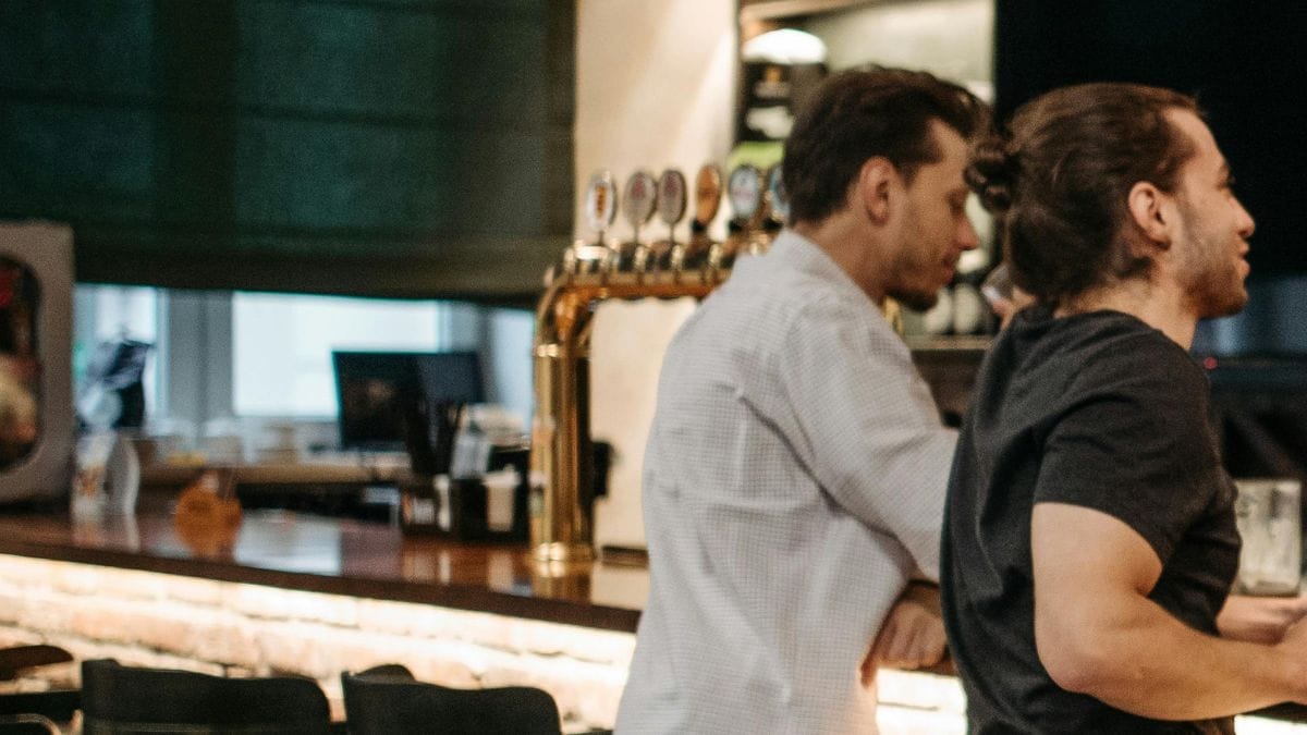 Dois homens em um balcão de bar
