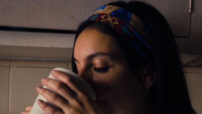 Moça bebendo café e usando faixa de cabelo