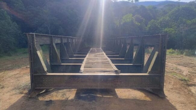 Segundo dados da Prefeitura de Prados, a ponte foi construída na Inglaterra no final do século XIX e chegou ao Brasil para integrar a infraestrutura ferroviária da antiga Ferrovia Oeste de Minas