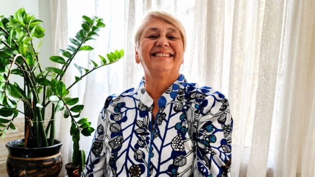 Sarah da Cruz Marina posa para foto ao lado de um vaso de plantas