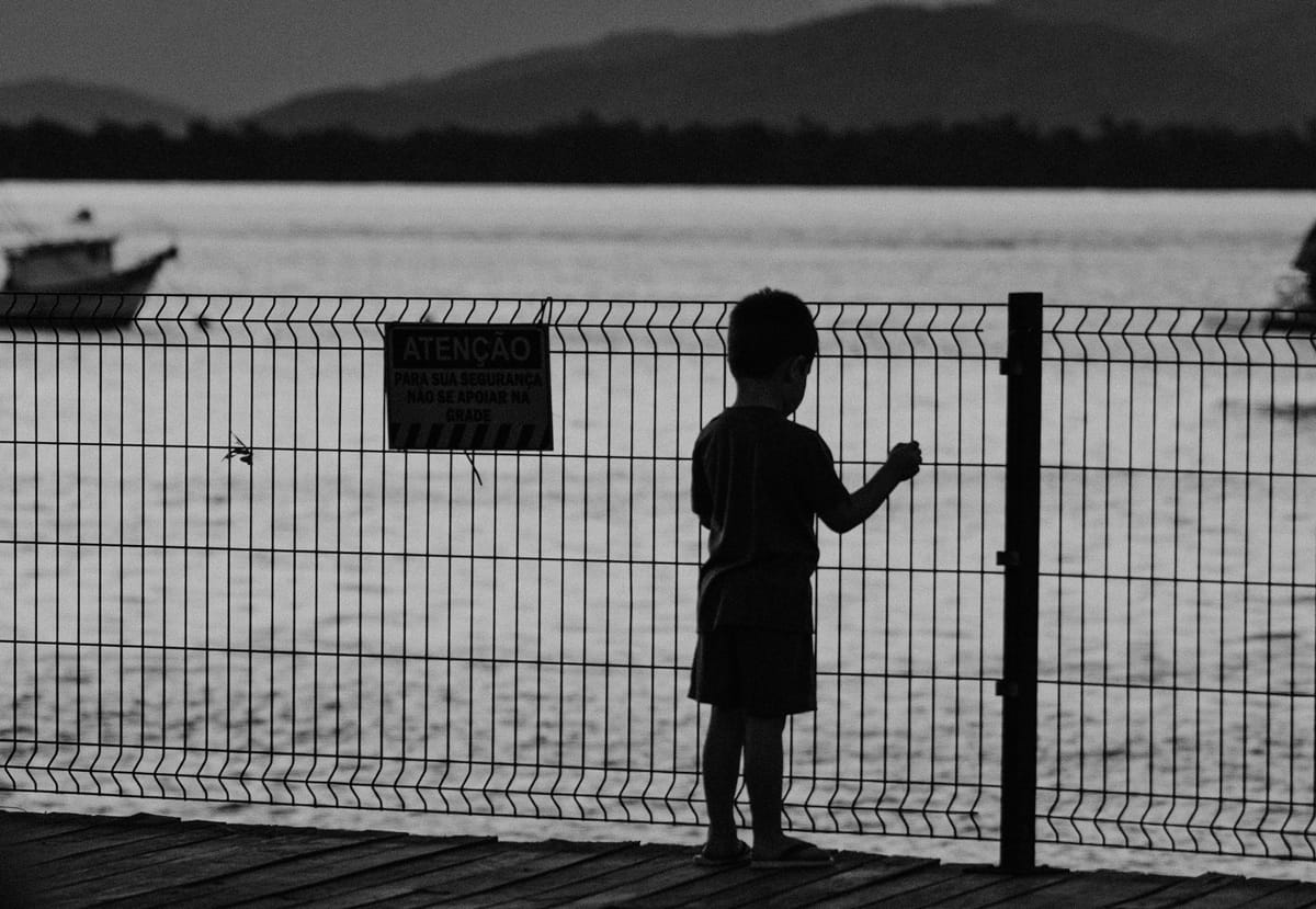 Criança sozinha em gradil