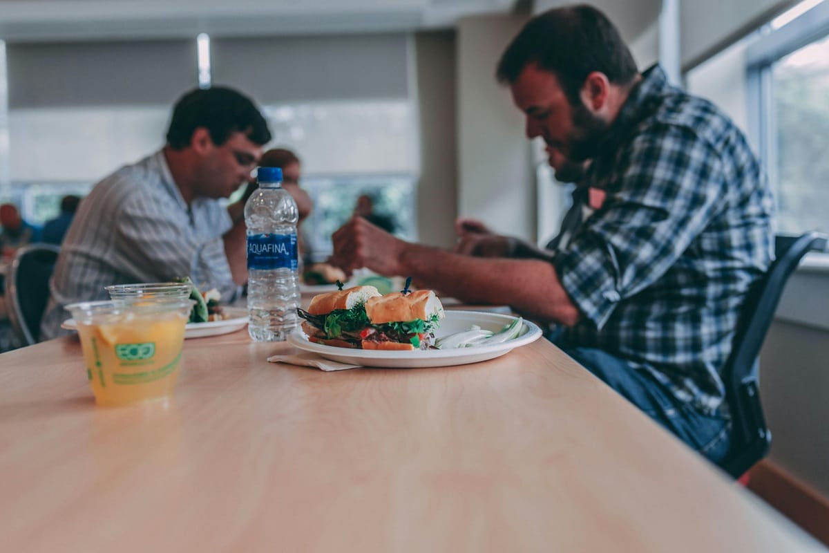 Grupo de trabalhadores almoçando no refeitório da empresa