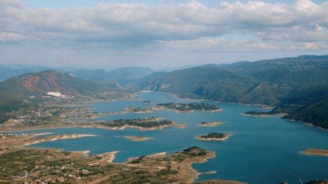 Fotografia aérea de grande altitude exibindo o Lago Rama com suas ilhas e penínsulas de águas azuis na Bósnia