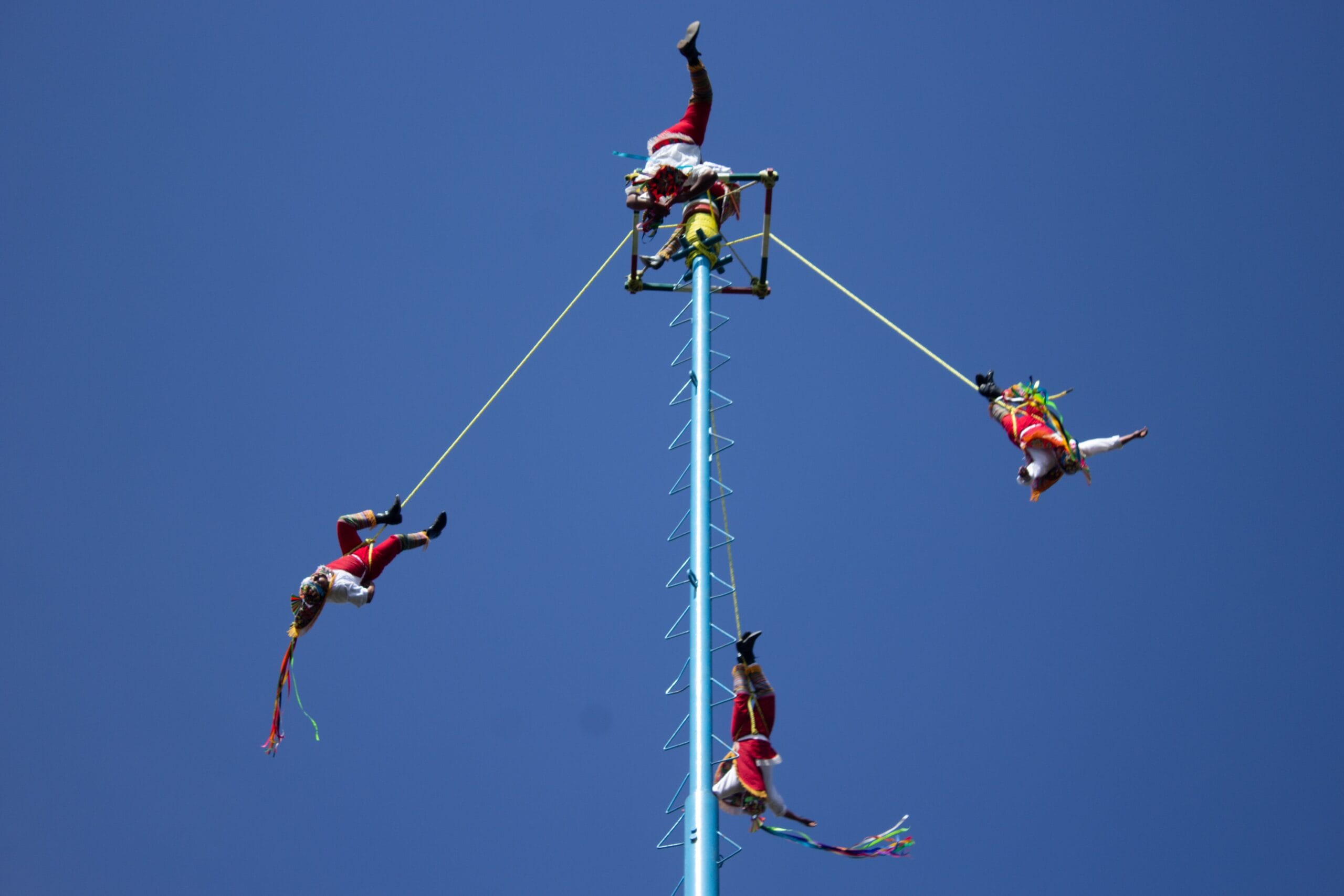 Participante suspenso por corda elástica após salto.
