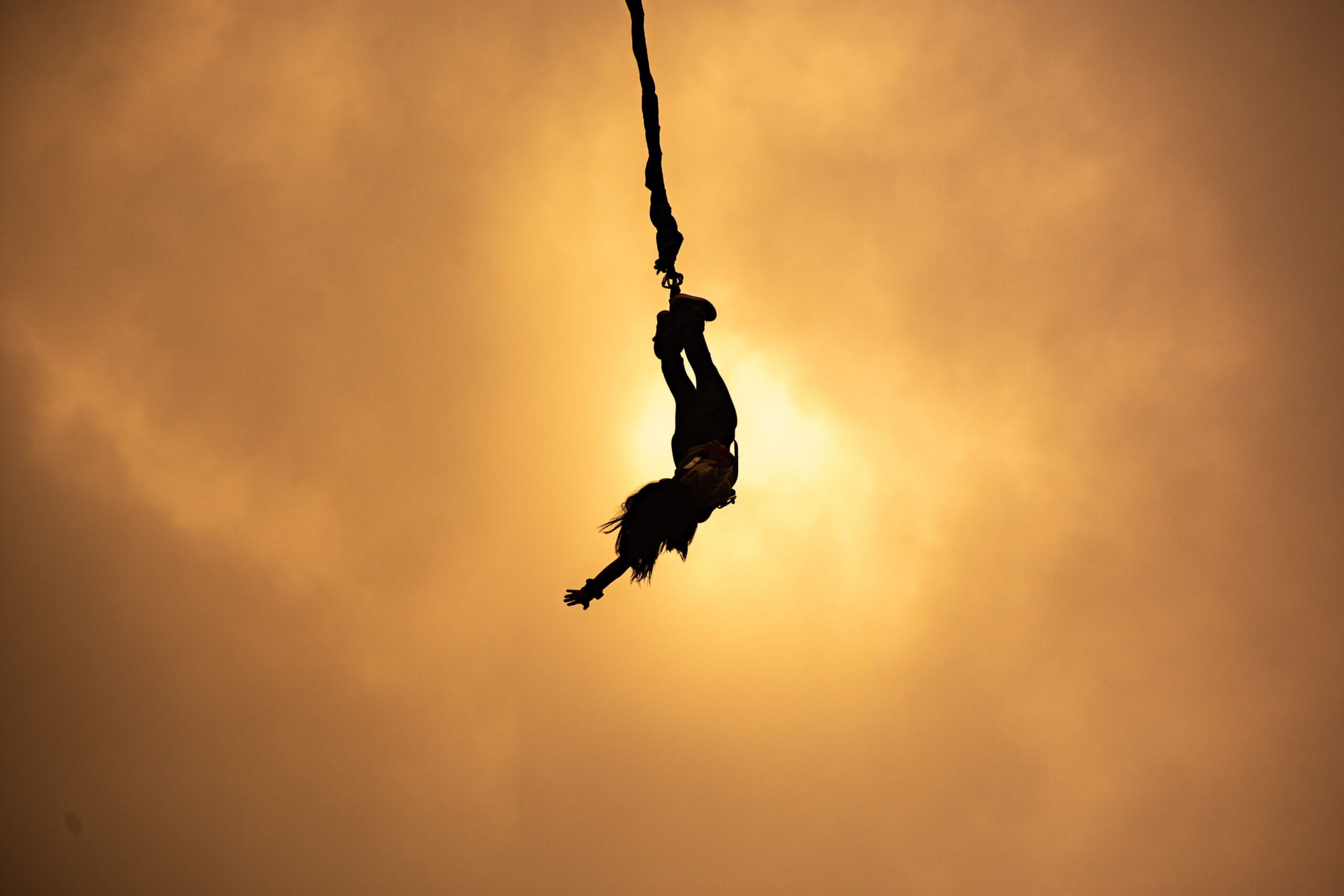 Participante balança no ar após salto de rope jump.