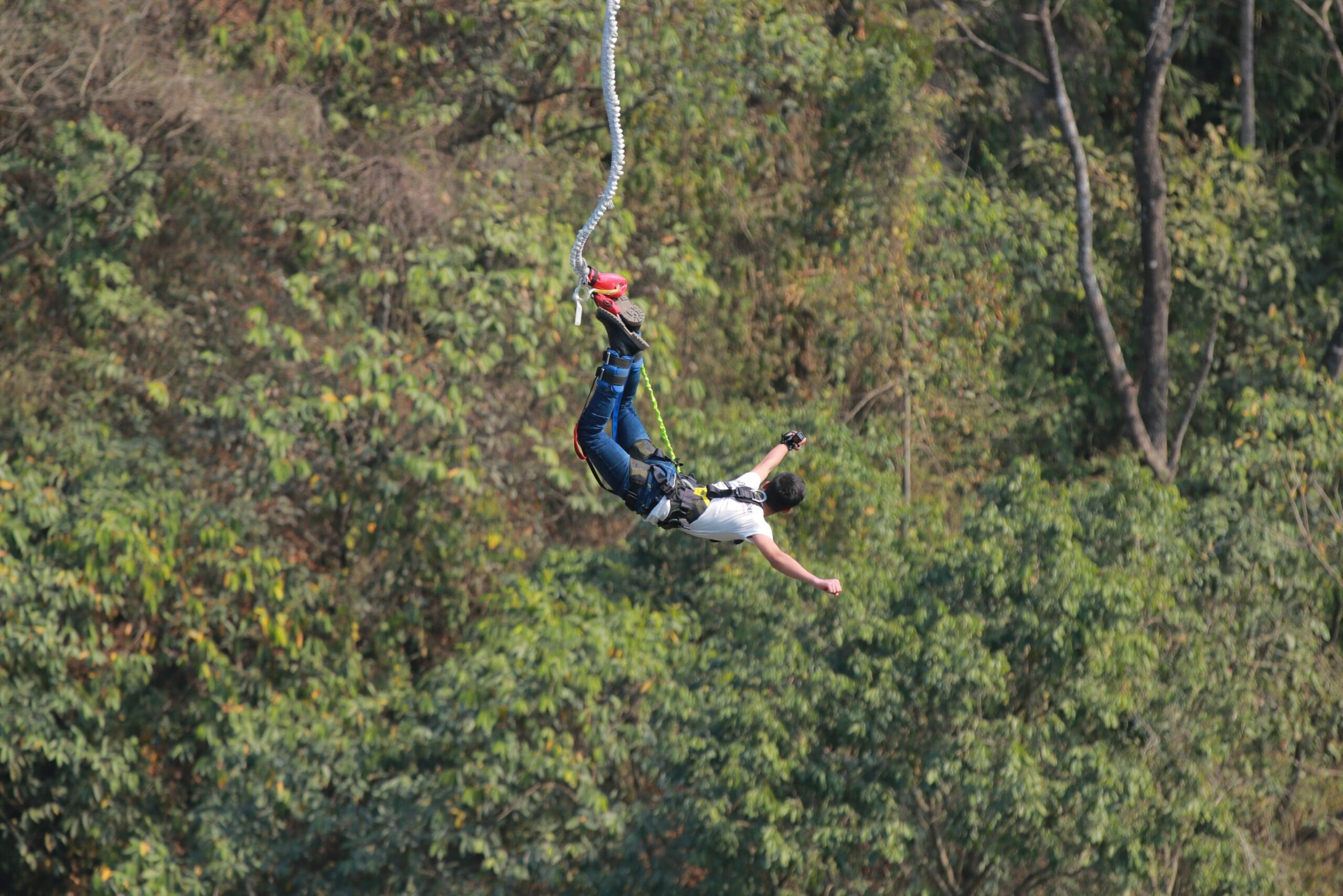 Praticante realiza salto de bungee jump preso a uma corda elástica.