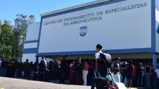 A segunda imagem mostra a fachada de um prédio moderno pintado em tons de branco e azul, identificado pela inscrição metálica em destaque: "CENTRO DE TREINAMENTO DE ESPECIALISTAS DA AERONÁUTICA" e, logo abaixo, o logotipo azul e branco com a sigla EEAR. Em frente à entrada, há uma grande movimentação de pessoas. Vários jovens e civis, alguns carregando malas de viagem e mochilas, circulam ou aguardam no local em um dia ensolarado, indicando um momento de recepção, apresentação ou início de atividades na instituição.