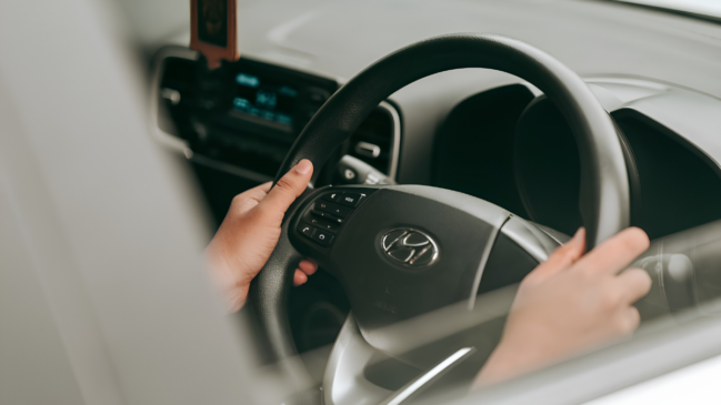 Uma mão segurando no volante de um carro