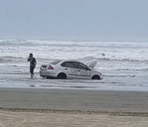 Homem atola carro em praia de Itanhaém e maré quase leva o veículo