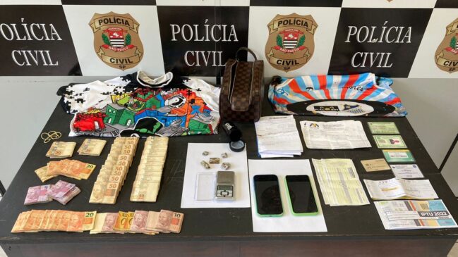 Na busca feita no imóvel foram localizados R$ 25 mil escondidos em uma bolsa, balança de precisão, cartões bancários, anotações sobre a contabilidade financeira da organização criminosa e documentos pessoais falsificados