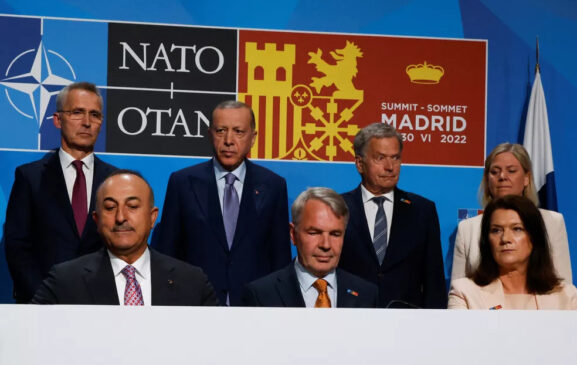 Representantes europeus diante de banner da conferência da Otan em Madri