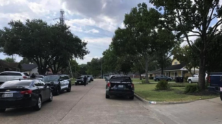 Carros de polícia em frente à casa onde foi encontrada a ossada