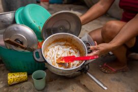 Mulher mostra panela vazia no local que antes era o seu barraco, em Alagoas. Nova pesquisa mostra que internações de bebês associadas com desnutrição aumentou em 2021