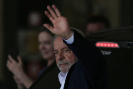 O presidente eleito Lula acena a jornalistas em Brasília