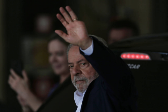 O presidente eleito Lula acena a jornalistas em Brasília