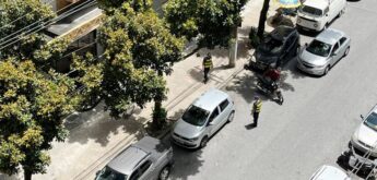 Motociclista levanta a moto ao lado da GCM e do carro que a teria atingido ao estacionar