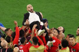 Seleção de Marrocos celebra com seu treinador sua classificação para as Quartas da Copa do Mundo