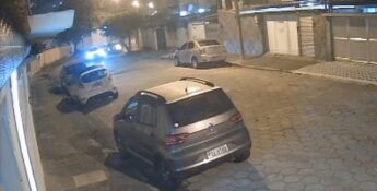 Nas imagens, é possível ver um carro branco entrando na rua e dele descendo algumas pessoas.