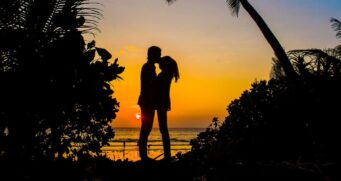Casal apaixonado curte final da tarde na praia