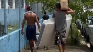 Moradores estão recebendo colchão e materiais na saída do abrigo