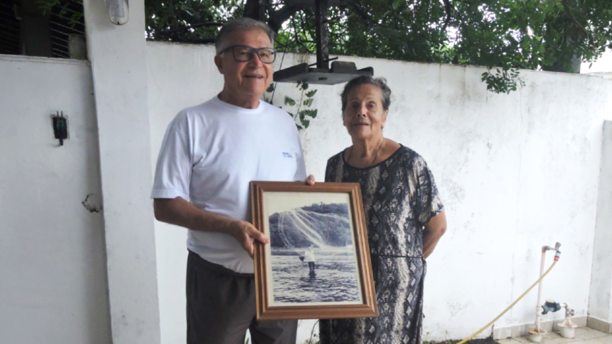 Manoel e sua irmã Marilene mostram o quadro com o seu pai Zeca Poitena e a rede de pesca