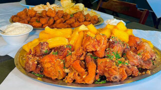 O prato vem com diversas opções de acompanhamentos, entre elas tem batata frita, mandioca frita e polenta frita.
