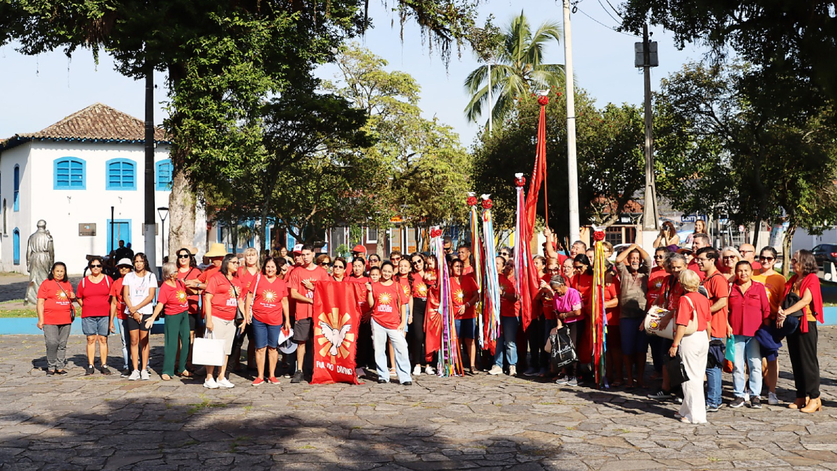 Fieis participam da Folia do Divino e levam a bandeira no bairro Rio Acima, em Itanhaém