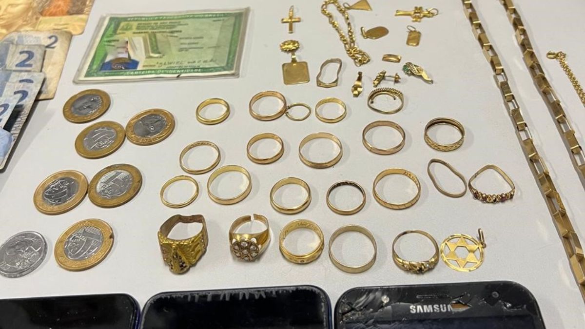 Dezessete alianças, 19 correntes de ouro, 10 pingentes, 05 anéis, 4 pulseiras, 3 brincos, 4 pedaços de ouro, uma balança de precisão, uma caixa de joias, cinco celulares. Crédito: Polícia Civil/SP