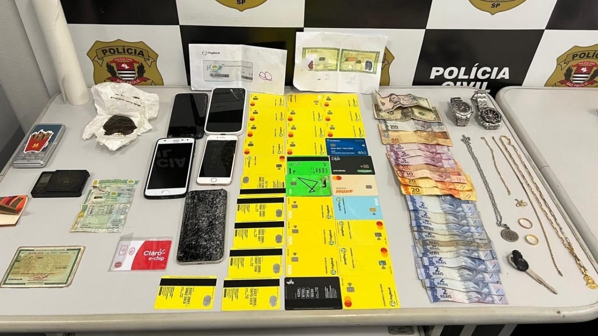 Trinta e dois cartões bancários em nome de terceiros, 21 gramas da droga sintética ICE, duas balanças de precisão, R$ 375,00 em espécie, USD 6,00, além de diversas joias. Créditos: Polícia Civil SP