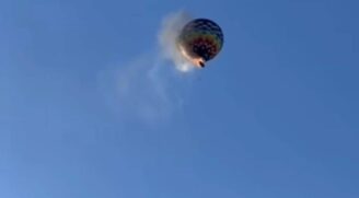 Em um céu extremamente azul, é possível ver que um incêndio tomou conta do balão antes de ele se chocar contra o solo.
