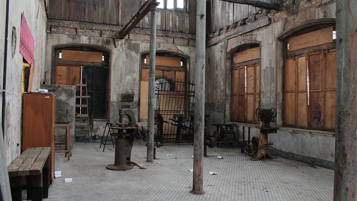 Vista interna da antiga fábrica de calçados e chapéus, com maquinário ainda preservado em meio ao abandono/ CapozziBruno/Wikimedia Commons