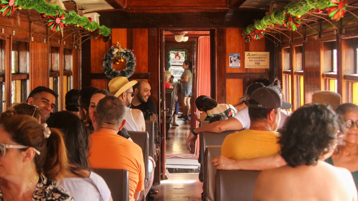 Dentro dos vagões históricos, a decoração especial e as músicas natalinas transformam o passeio em uma experiência encantadora/ Reprodução Facebook/Trem Caiçara