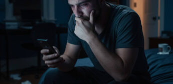 Homem chora enquanto aguarda uma resposta no celular que jamais virá