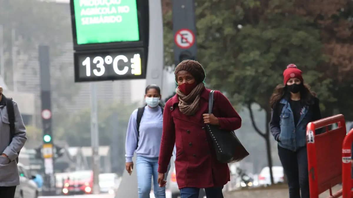 Pessoas bem agasalhadas na rua durante frio fora de época